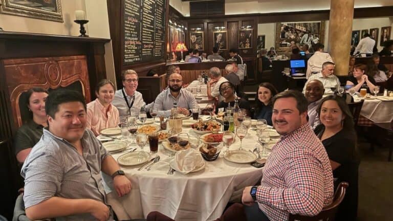 A group of coworkers smile together at a luncheon